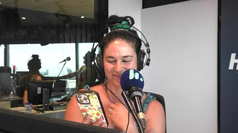 Jess in studio looking at her phone and smiling.