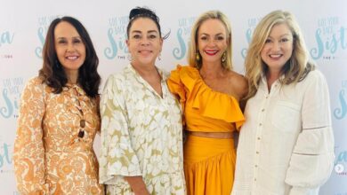Women posing together in front of Got Your Back Sista signage.