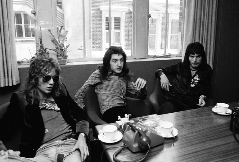 Roger Taylor, John Deacon and Freddie Mercury of Queen being interviewed at their office in London for Japanese music magazine 'Music Life', 13th June 1974. Brian May was absent because of flu.