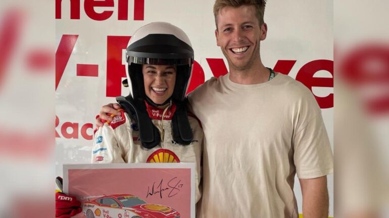Jess in a supercars jumpsuit and helmet with husband Angus.