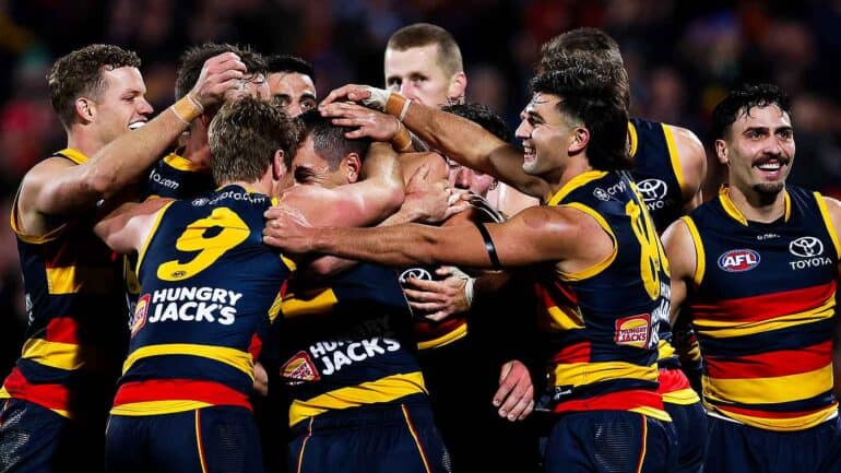 Crows players celebrate with Tex Walker after he kicked his 10th goal against West Coast.