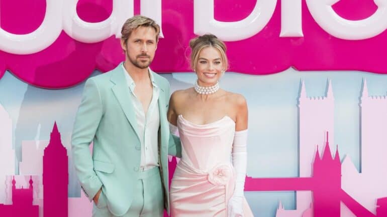 Margot Robbie and Ryan Gosling in front of Barbie backdrop.