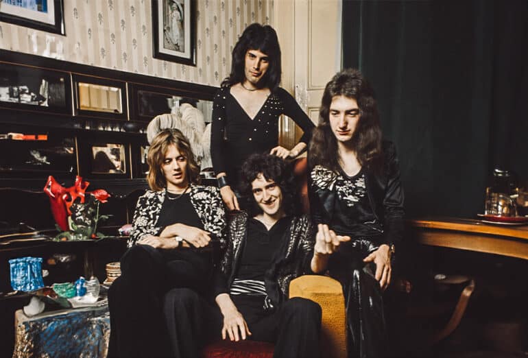 Queen posed in lead singer Freddie Mercury's flat, Holland Road, West Kensington, London in early 1974. Left to right: Roger Taylor, Freddie Mercury (1946-1991), Brian May (bottom) and John Deacon. (Photo by Mark and Colleen Hayward/Redferns)(Edit by Kalun Townsend/LiSTNR)