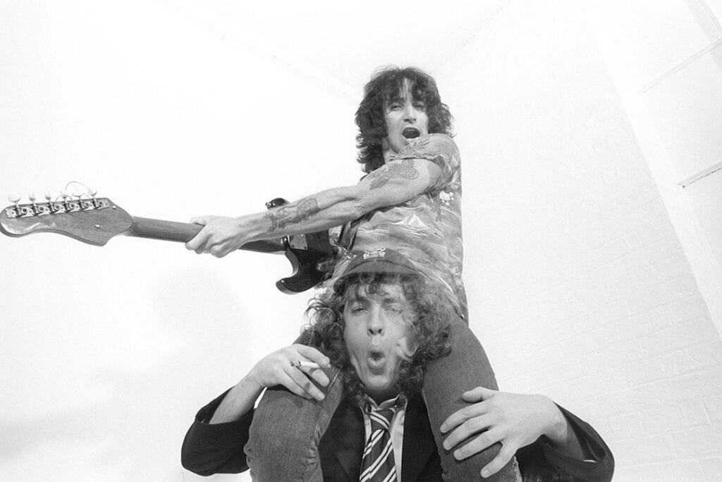 AUGUST 01 1979: CAMDEN, ENGLAND. AC/DC's Bon Scott sitting on Angus Young's shoulders (Photo by Fin Costello/Redferns)