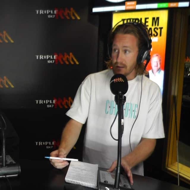 Producer Jarryd with headphones on speaks into a microphone