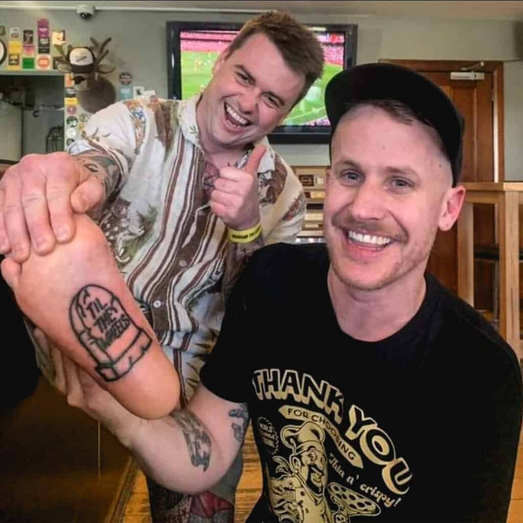Luca Brasi frontman Tyler Richardson (right) pictured with a long time fan of the band who has tattoos the logo for 'Til The Wheels Fall Off Festival' on the bottom of their right foot.