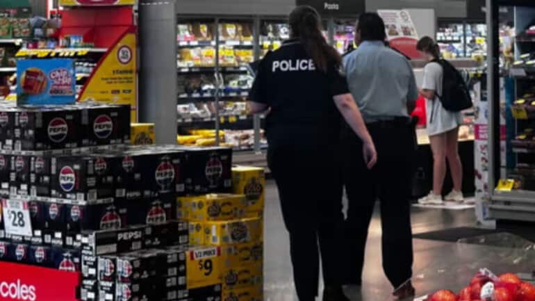 Queensland police enter the Coles in Yamanto Central shopping centre in Ipswich, where a worker was stabbed on Monday.