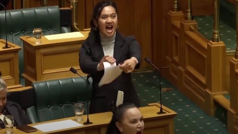 Three Māori Party MPs have been temporarily suspended in New Zealand parliament after performing a haka in the debating chamber during a protest against the Treaty Principles Bill.